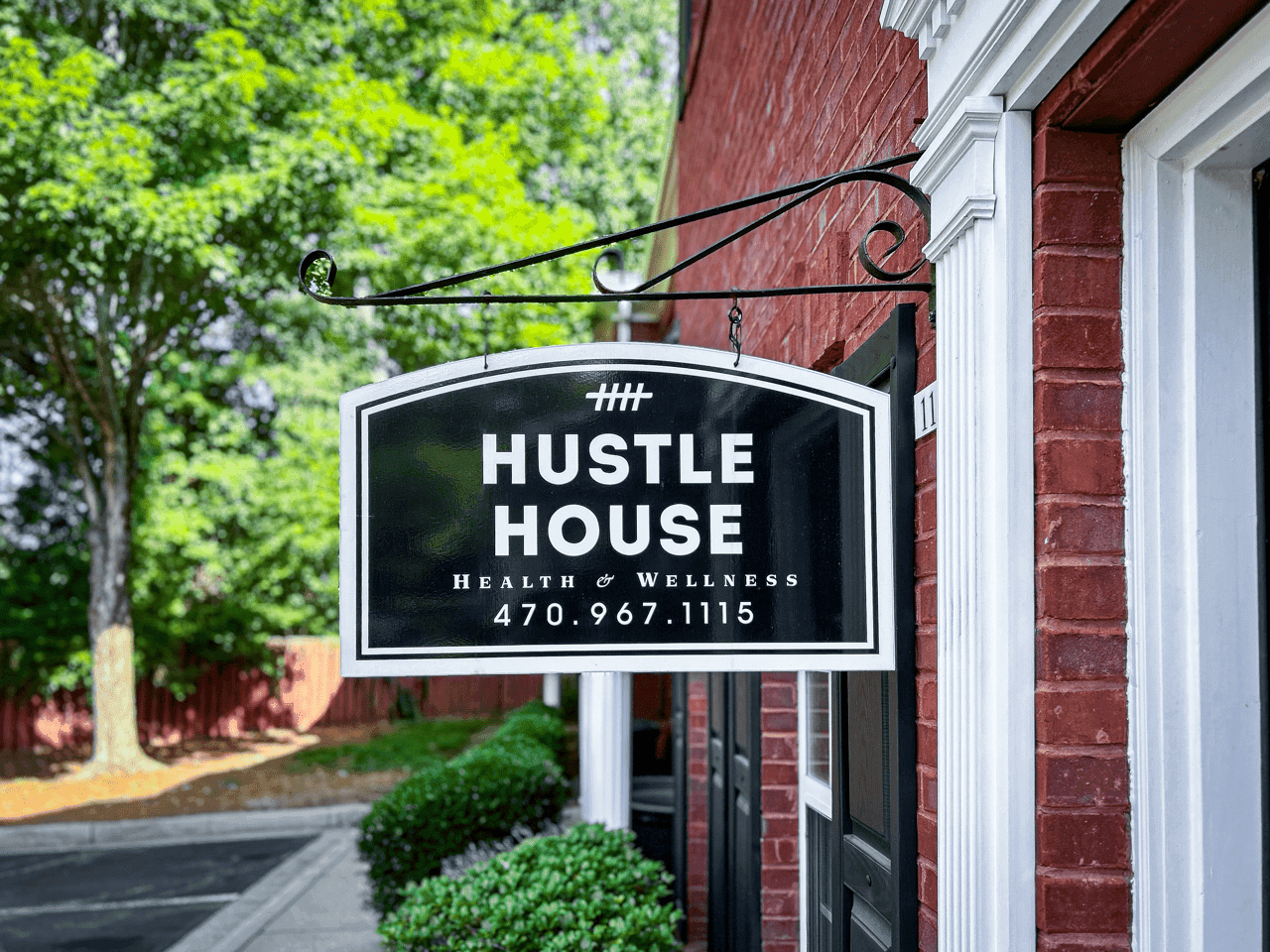 The Hustle House Health & Wellness sign on the building exterior in Woodstock, GA