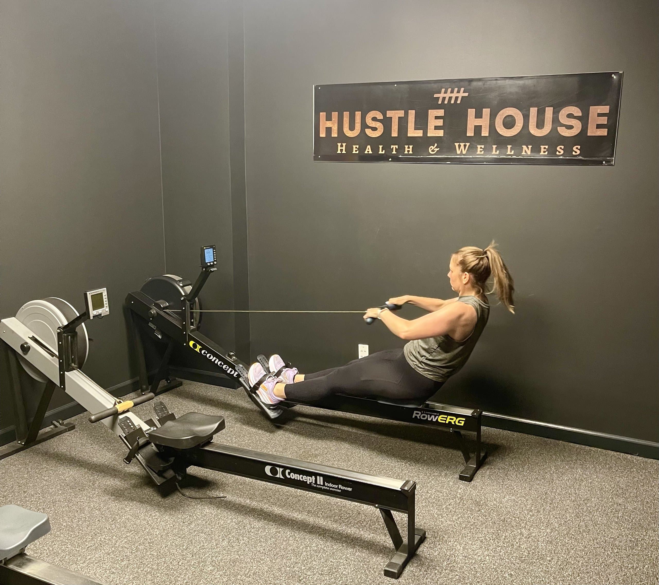 A member rowing for cardiovascular conditioning at Hustle House Health & Wellness in Woodstock, GA