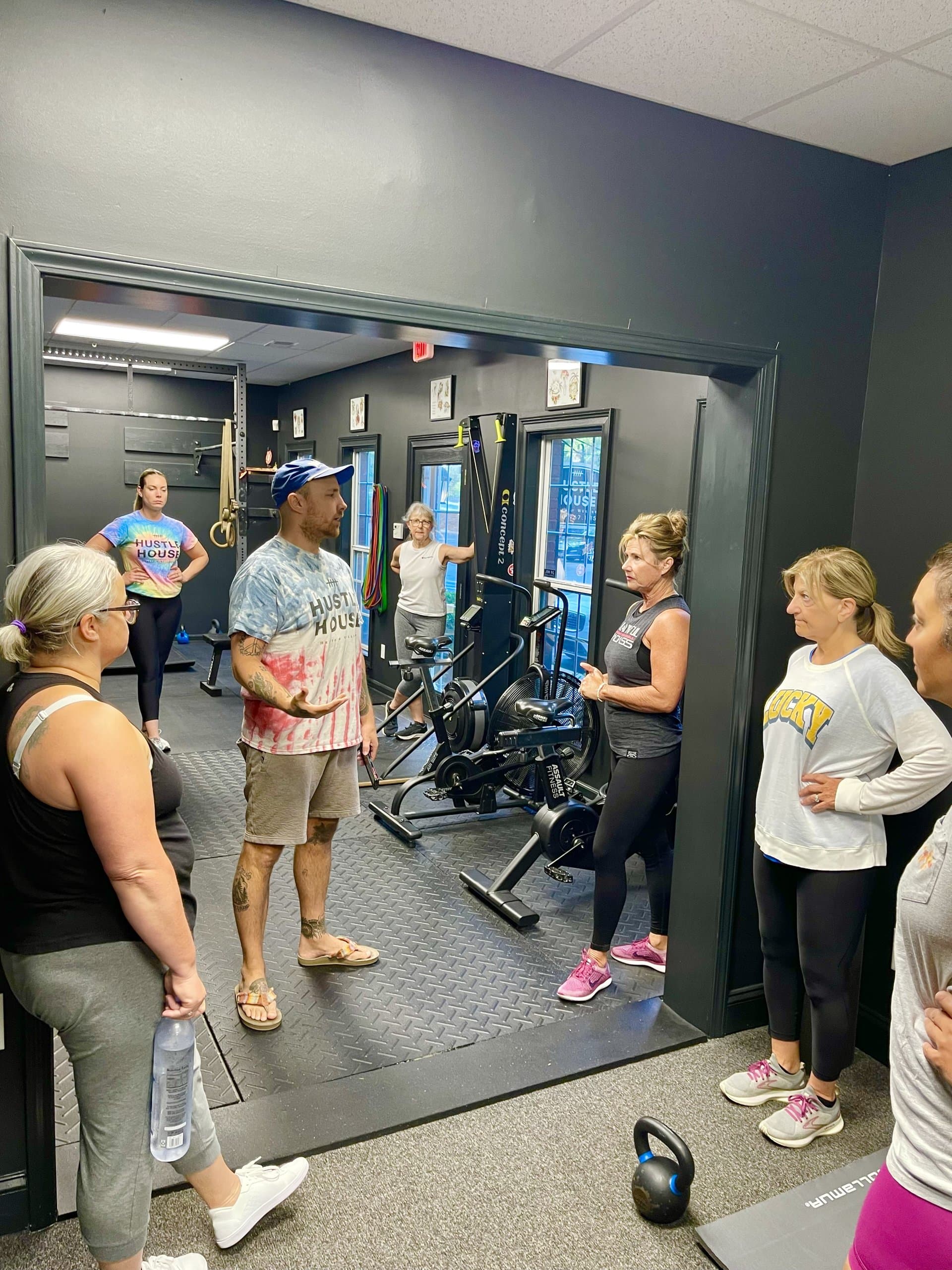 A coach briefing a group of members before class at Hustle House Health & Wellness in Woodstock, GA