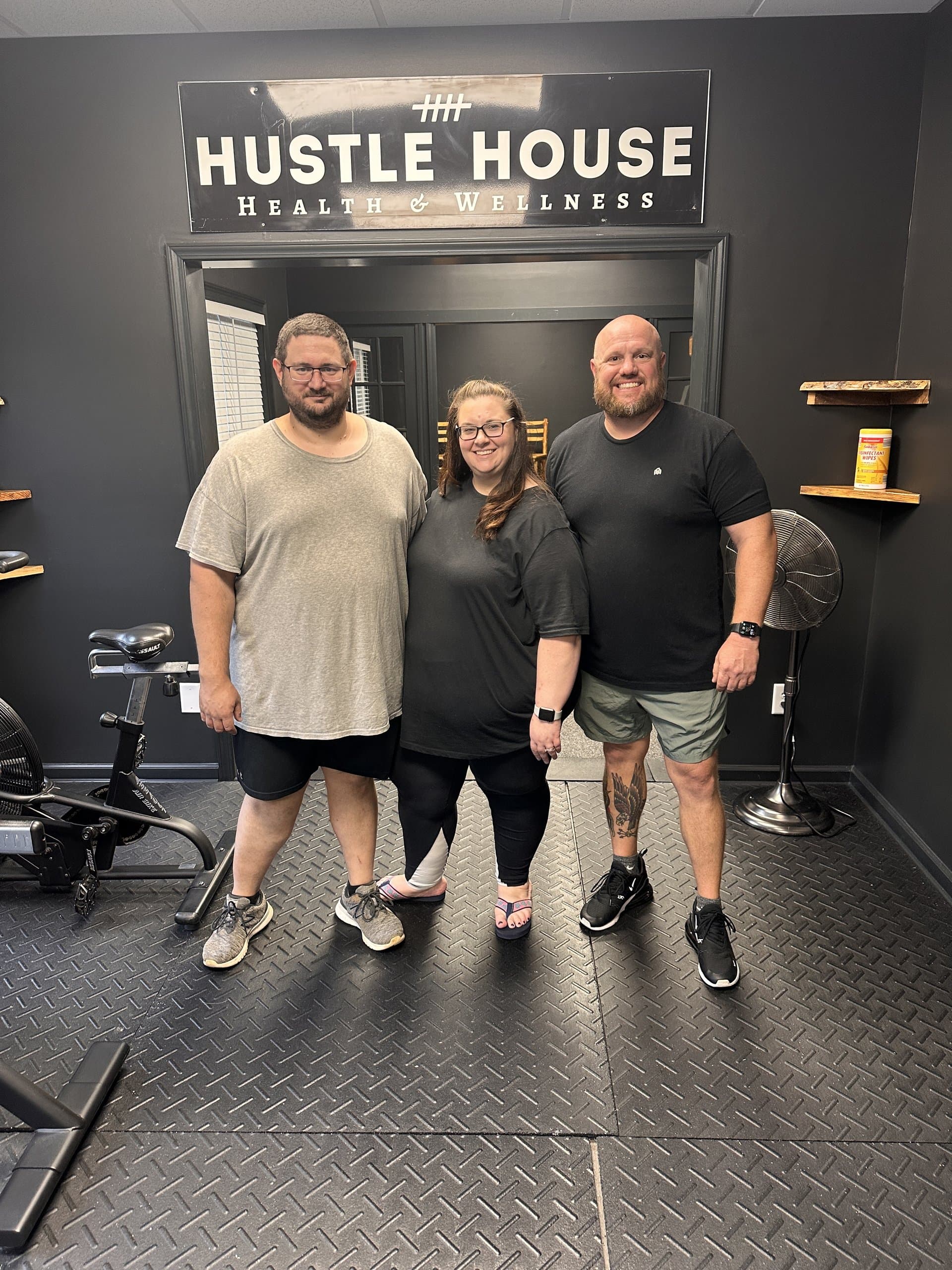 Members and coaches beneath the Hustle House Health & Wellness sign in Woodstock, GA