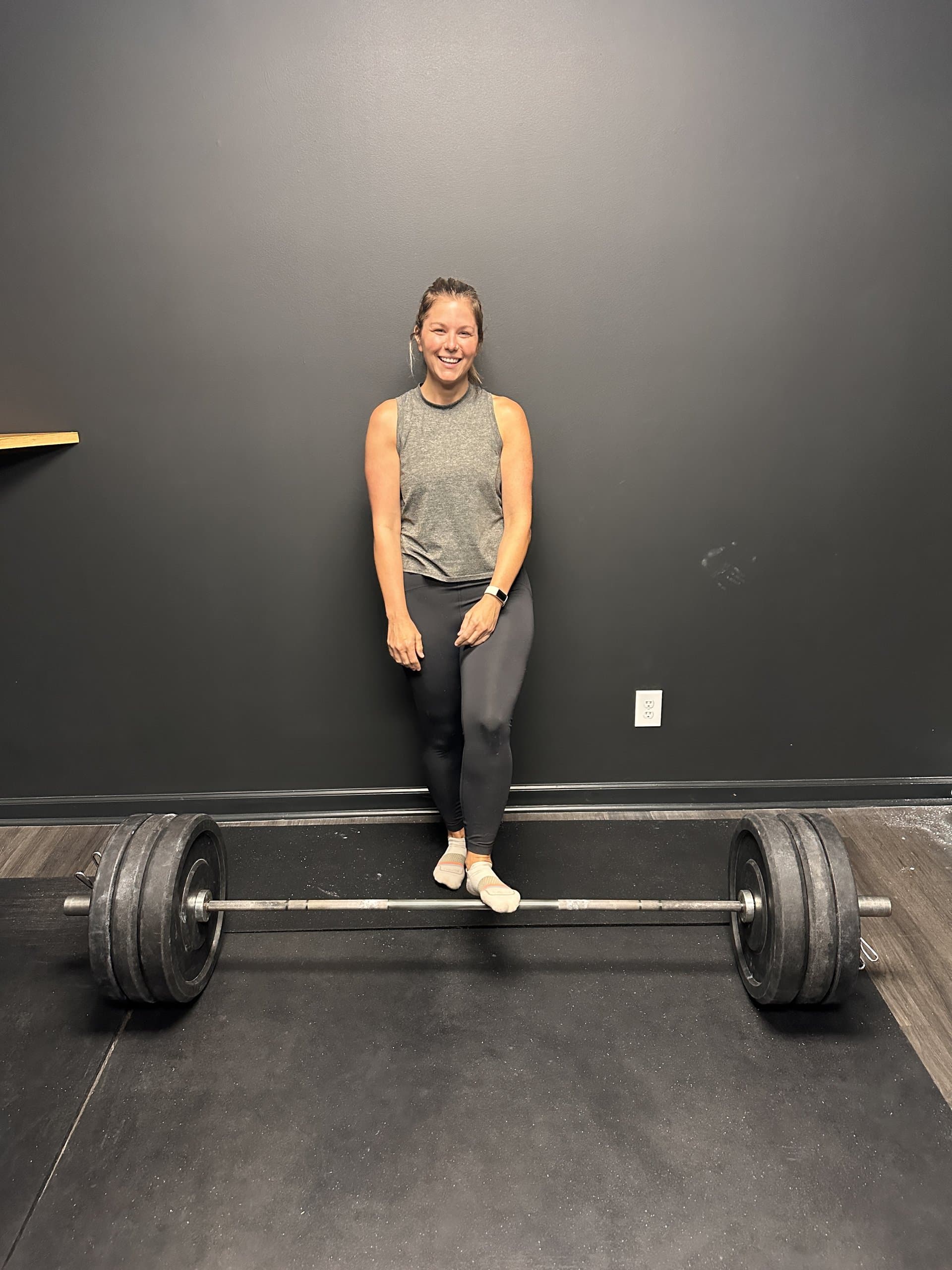 A member preparing to deadlift a loaded barbell at Hustle House Health & Wellness in Woodstock, GA